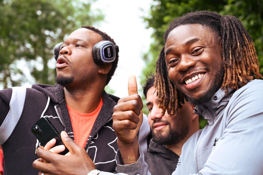 Trois amis tout sourire, pouce levé, casques sur les oreilles